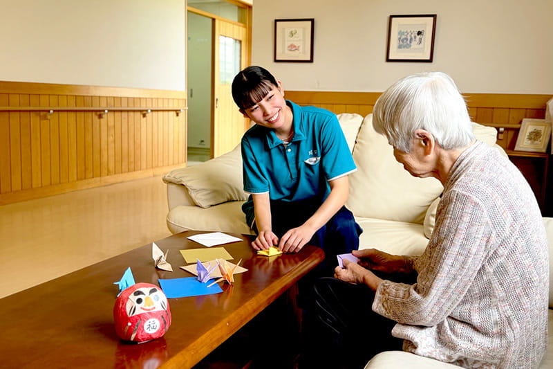 折り紙をする利用者と職員