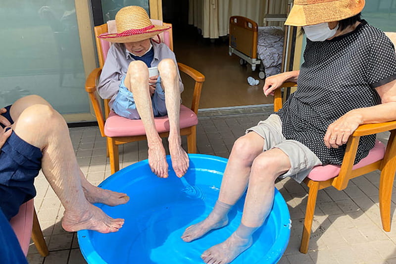 水を張った桶に足を入れる利用者